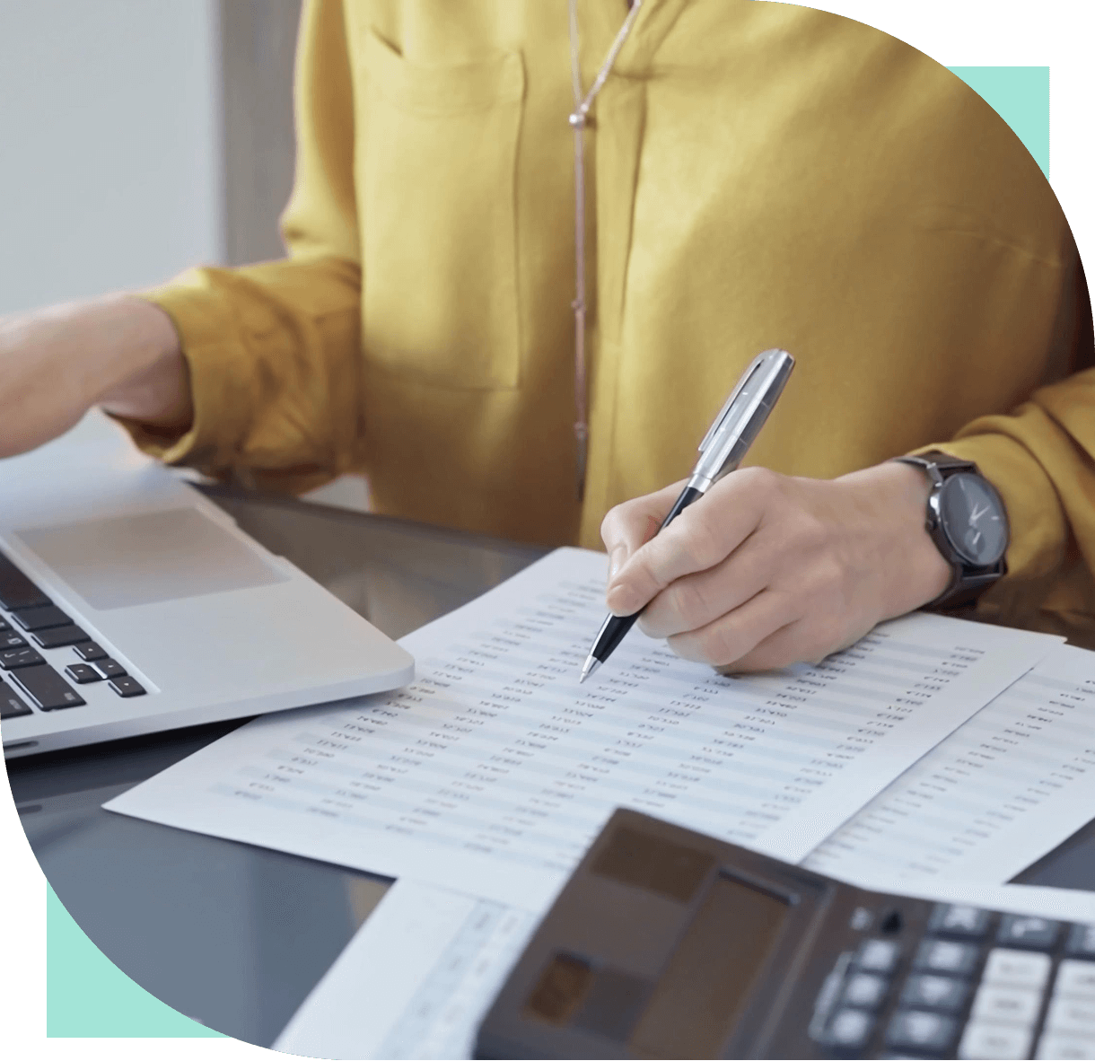Person working with laptop and documents.